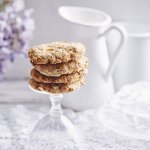 Heerlijke homemade cookies. Wij maakte er met appeltjes en pindakaas, een topcominatie. Ze liggen op de voet van een omgedraaid wijnglas. Achteraan de foto vind je een bloem van een Blauwe regen, melkkan en koffiekan. 