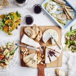 De tafel staat klaar om aan te vallen. Er staat een kaasplank op met Belgische kazen en verschillende bijgerechten met fruit en groenten. Wijn en brood mogen natuurlijk niet ontbreken bij deze pittige kazen.