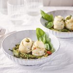 Twee bordjes staan op tafel, het zijn diepe borden in een lichtblauwe/grijze kleur. Ze zijn gevuld met de lente-uitjes en zeekraal op de bodem in een nestjesvorm. Hier bovenop liggen de schartongrolletjes. Het gerechtje is afgewerkt met de tomatenboter en crumble van ansjovis en peterselie.