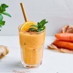 Op het aanrecht staat een knaloranje smoothie. Hoe? Door de wortel en sinaasappelsap. Wij maakten hem nog specialer door havermout, cashewnoten, gember en honing toe te voegen. 