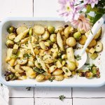 Een heerlijk geurende ovenschotel staat op het aanrecht. Het is een traybake van aardappelen met spruitjes, pastinaak en Beauvoordse brokkelkaas.