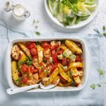 Een heerlijke hoofdmaaltijd in één ovenschaal met stukjes aardappel, tomaten, paprika en kip. Er is ook een knapperige salade van little gem met yoghurtdressing.