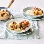 Een heerlijk én makkelijk ontbijtje staat klaar op tafel. De yoghurt is geserveerd in ontbijtkommetjes en afgewerkt met gegrilde druiven en krokante croutons van rozijnenbrood.