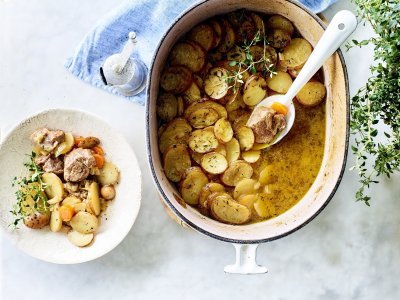 Stoofpotje met lamsvlees staat klaar op tafel om uit geschept te worden. Bovenop de stoofpot ligt een laagje krokante aardappelschijfjes. Deze stoofpot noemt men Lancashire hotpot. 