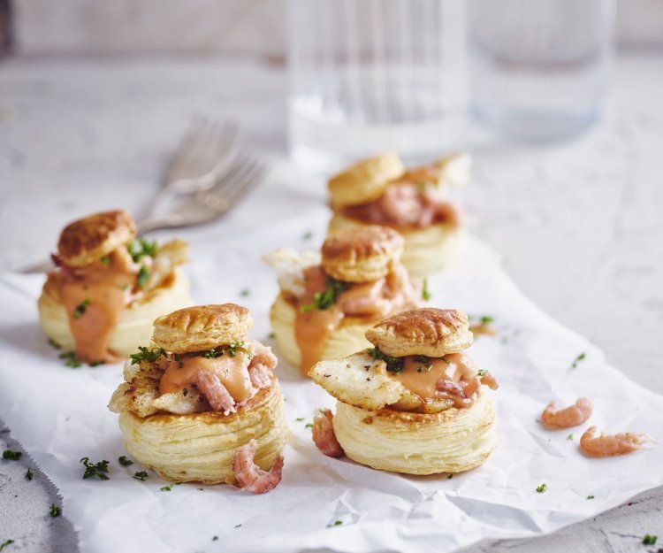 Bladerdeeghapje met een vol-au-vent van steenbolk Verschillende bladerdeeghapjes staan op tafel. Ze zijn gevuld met een vol-au-vent op basis van vis, nl steenbolk.