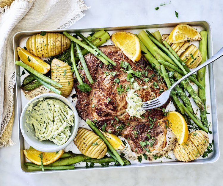 Gegrilde entrecôte met lookboter, hasselback aardappelen en groene groenten Een grote bakplaat gevuld met lekkers van bij ons, denk maar aan een mooi stukje vlees, groene asperges, boontjes, hasselback aardappelen en knoflookboter.