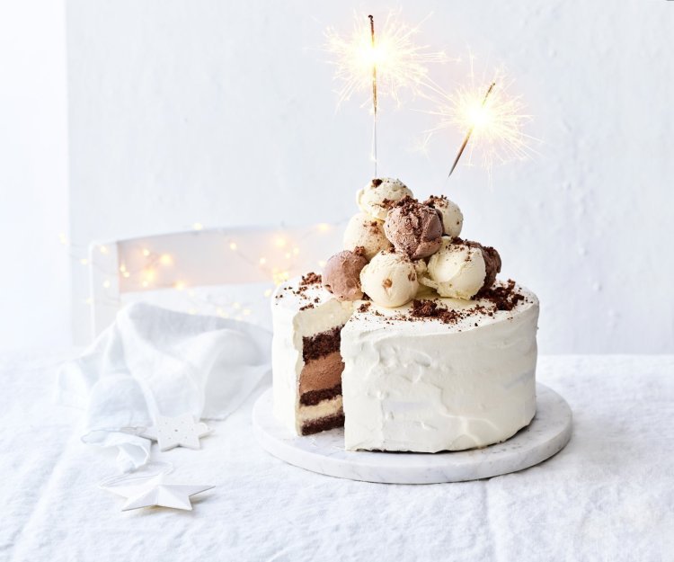 IJstaart van chocolade, gezouten karamel en vanille Een prachtige laagjestaart opgebouwd uit chocolade biscuit, vanille-ijs, karamelijs en chocolade-ijs. De taart kreeg een witte afwerkingslaag aan de buitenkant en aan de bovenzijde liggen verschillende bollen ijs. Als afsluiter werden er sterrenstokjes aangestoken bovenop de taart.