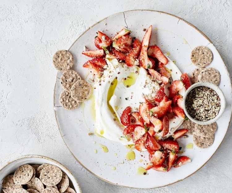 Smeuïge kaasdip met kruidige aardbeien en crackers. Perfect zomers hapje om het aperitief mee te starten.