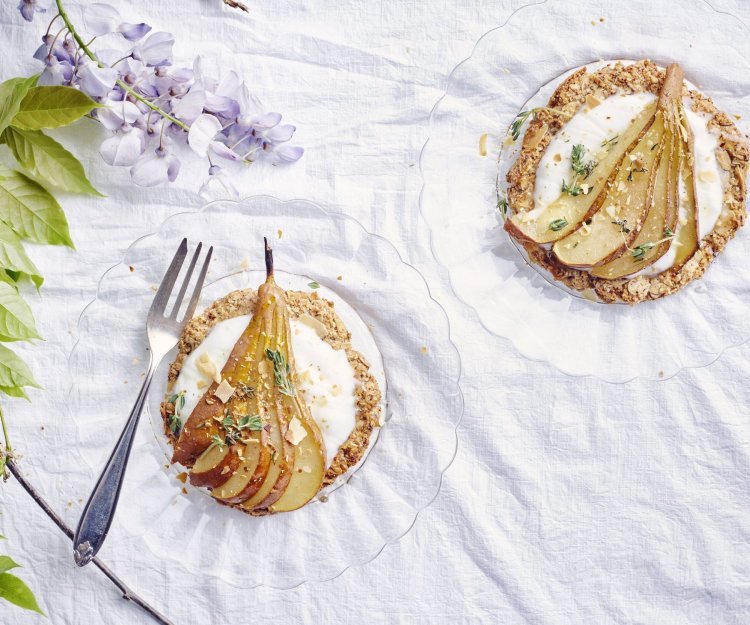 Krokante perentaart Deze taart heeft een krokante bodem van amandel en hazelnoten. Ze is bedekt met yoghurt, honing, tijm en een heerlijke verse peer van bij ons!