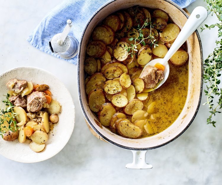 Stoofpotje met lamsvlees staat klaar op tafel om uit geschept te worden. Bovenop de stoofpot ligt een laagje krokante aardappelschijfjes. Deze stoofpot noemt men Lancashire hotpot. 