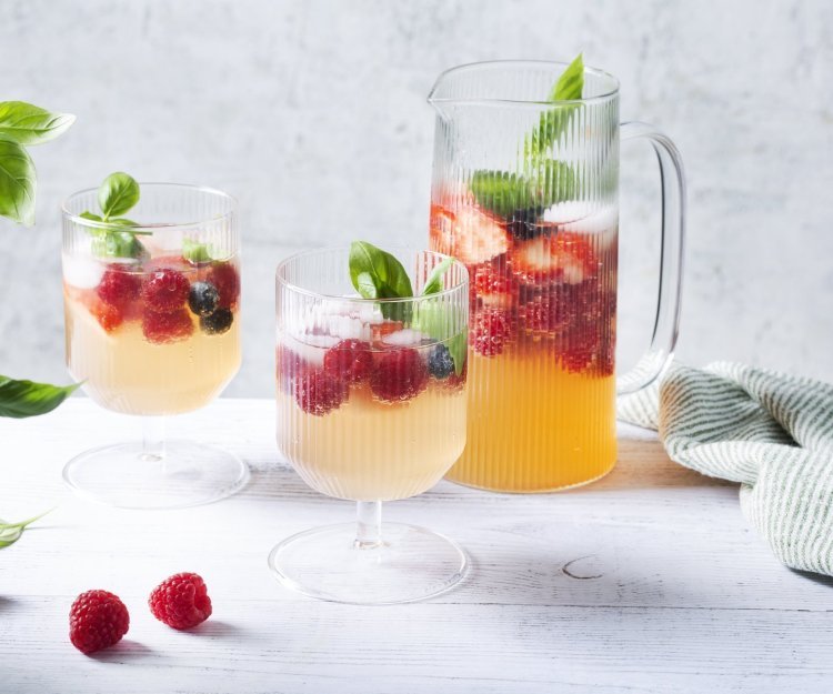 Mocktail met kombucha, frambozen en blauwe bessen Een heerlijke verkoelende mocktail klaargemaakt in een grote karaf. Er werden al twee glaasje uitgeschonken met verse framboosjes en basilicum afgewerkt. Een plaatje om naar te kijken en er meteen van te drinken.