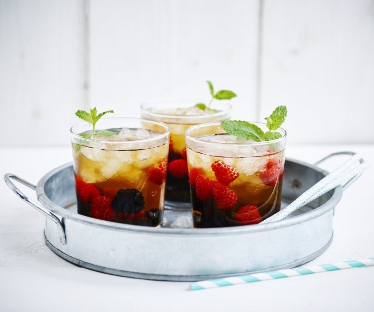 Mocktea van rood fruit Een homemade mocktea van rood zomerfruit. Gepresenteerd in glaze theeglaasjes op een inox dienblad, klaar om te brengen naar de gasten en aan te vallen.