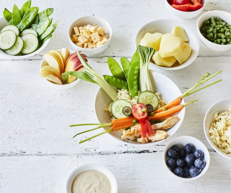 Een grappige én gezonde poké bowl op kindermaat. Wij maakten eentje in de vorm van een konijn. Oren van paksoi, ogen van komkommerschijfjes, neusje van tomaat, snorharen van worteltjes, tanden met paprika en mondje van kipfilet. Er staan ook nog enkele kleine potje langs gevuld met schijfjes appel, stukjes kaas, blauwe bessen... Laat ze maar kiezen en eten.