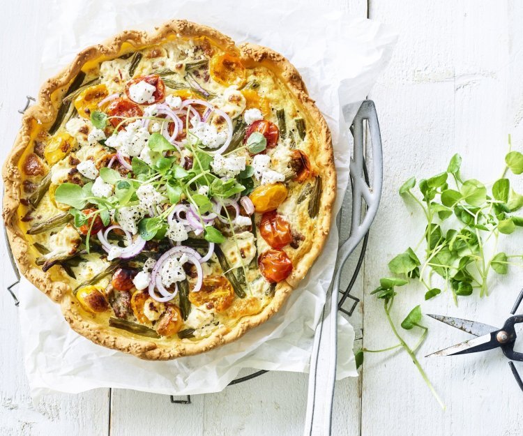 Quiche met boontjes, kerstomaat, lamsgehakt en geitenkaas Kleurrijke quiche gevuld met boontjes, kertomaat, geitenkaas en lamsgehakt. Ja, eentje met gehakt. We werken hem af met verse rode ui en waterkers. Ten aanval!
