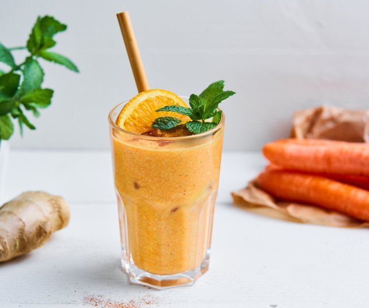Smoothie van wortel, havermout en sinaasappel Op het aanrecht staat een knaloranje smoothie. Hoe? Door de wortel en sinaasappelsap. Wij maakten hem nog specialer door havermout, cashewnoten, gember en honing toe te voegen.