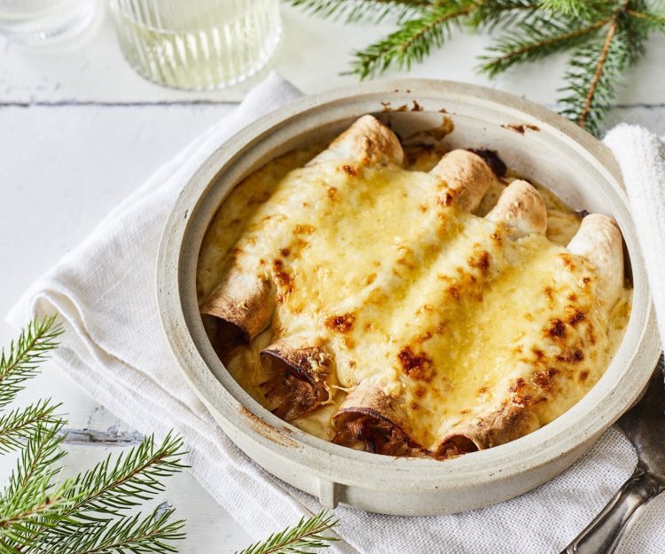 Taquitos met pulled rabbit en kaassaus Opgerolde wraps gevuld met traagggegaard vlees liggen netjes naast elkaar in een ovenschotel. Hierover is kaassaus geserverveerd en even gegrild. Perfecte snack als bijgerechtje op je feesttafel, heerlijk voor groot en klein.
