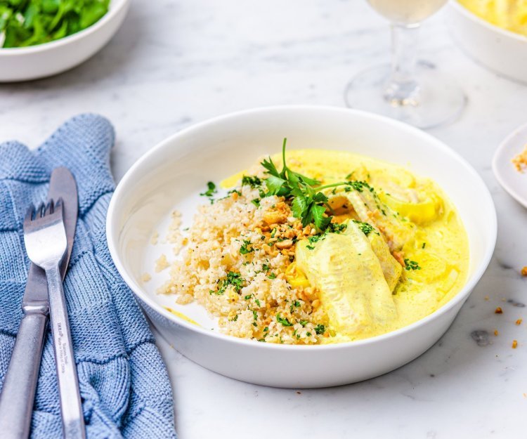 Dit gerechtje is er eentje om je broodje in te doppen, tongschar in currysaus met bloemkoolrijst. Er ligt een blauwe servette langs en een glaasje witte wijn. 