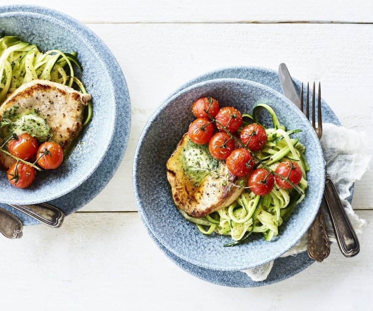 Een heerlijke stukje varkensfilet ligt op een bedje van courgetti. We dienen het gerechtje op met kruidenolie en ovengeroosterde kerstomaatjes. Het gerechtje is gepresenteerd in trendy blauw diep bordje.