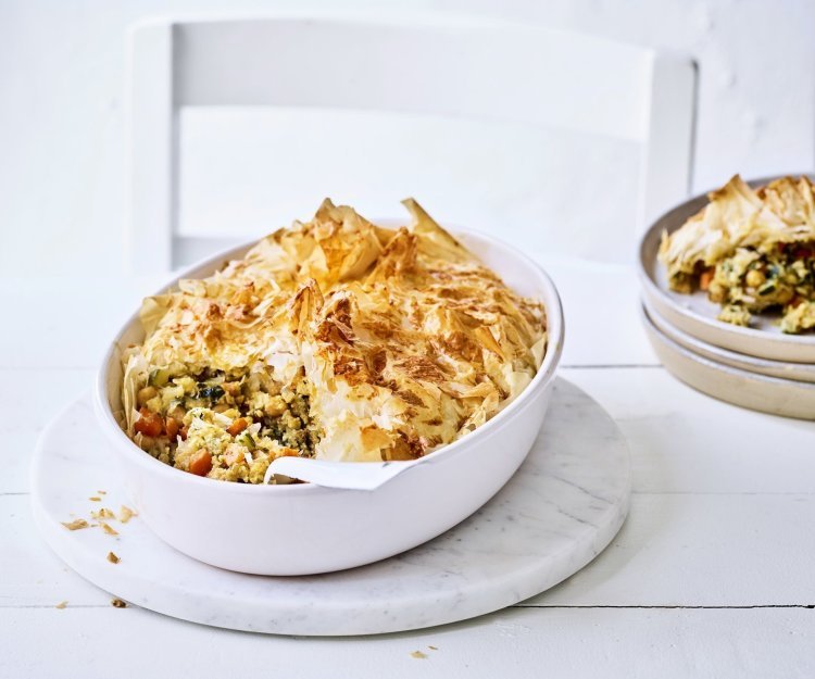 Pastilla is een hartige pastei met een zoete touch. Pastilla maak je met filodeeg, de traditionele is met kip maar wij maakte een vegetarische versie. Hier is hij opgediend in een grote witte ovenschotel waaruit al 1 portie is uitgeschept en naast de schotel staat.   