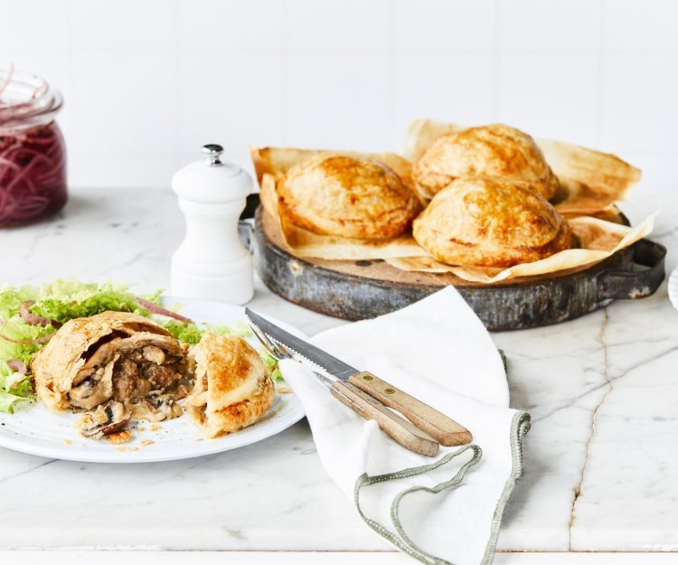 Vol-au-vent taartjes Achterin de foto staat een schaal met hierop 3 vol-au-vent taartjes. Vooraan in het beeld ligt er één taartje aangesneden. Met wat sla erbij en ingemaakte rode ui.