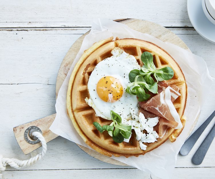 Gaufre de petit déjeuner avec œuf au plat, jambon cru et fromage de chèvre