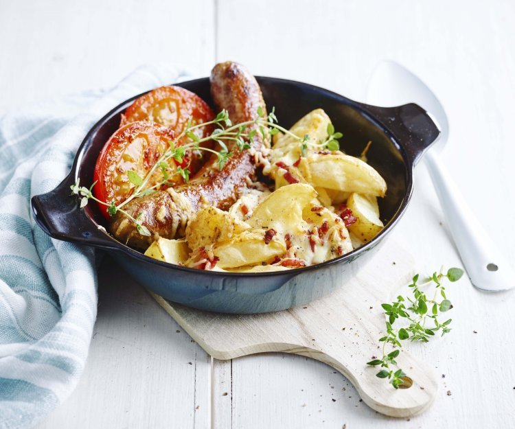 Quartiers de pommes de terre au fromage et crème épaisse, saucisse et tomates