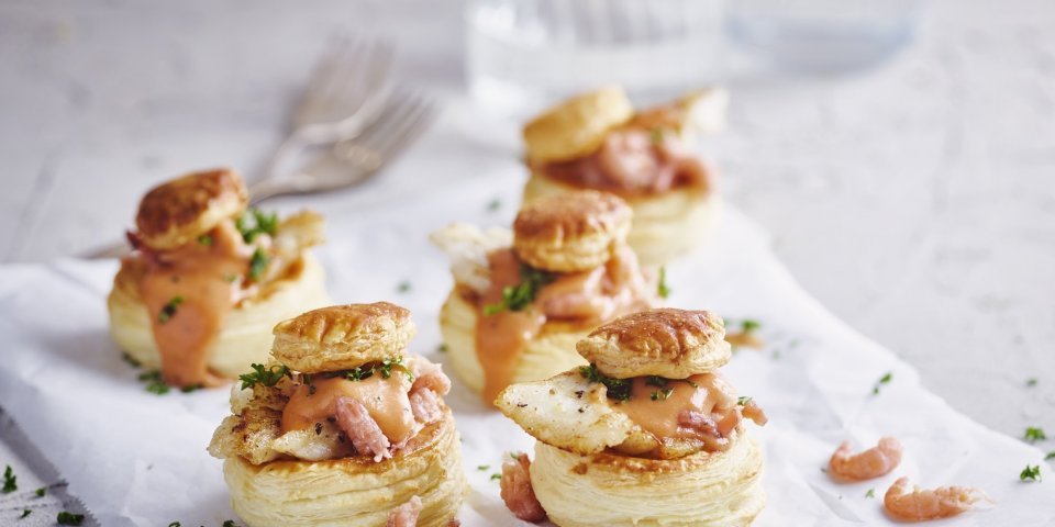 Bladerdeeghapje met een vol-au-vent van steenbolk Verschillende bladerdeeghapjes staan op tafel. Ze zijn gevuld met een vol-au-vent op basis van vis, nl steenbolk.