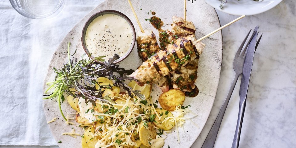 Brazade van kalfsvlees met aardappelen en truffelamyonaise Er staat al een porseleine schotel op tafel, een ei-vormige schaal. Gevuld met de brochettes van kalf, gebakken aardappelen en een potje met de truffelmayonaise.