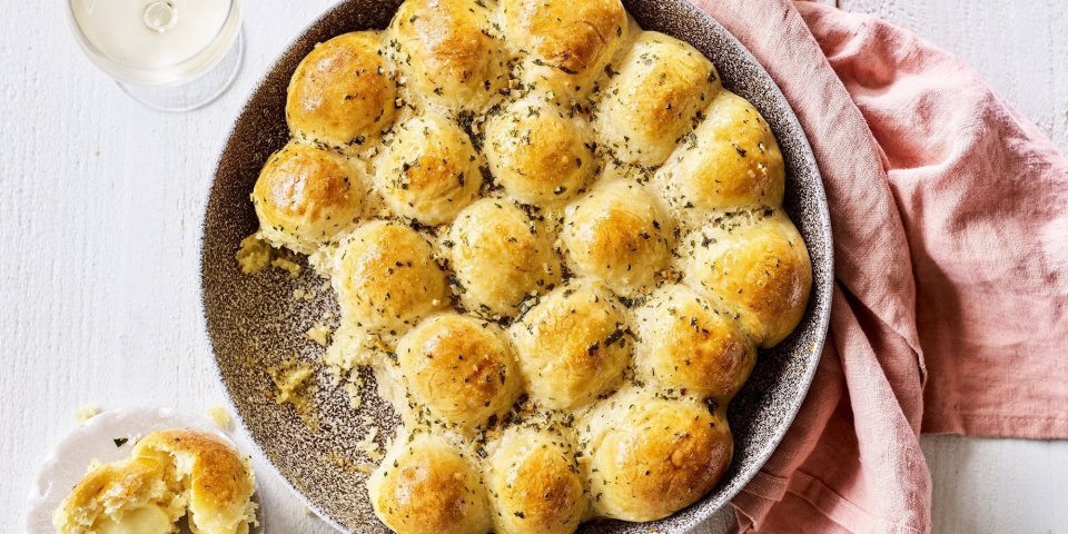 In het midden van de tafel vind je een groot rond keramiek bord in aardekleur. Hierin liggen de goudgele briochebroodjes met knoflookboter, en gevuld zijn met abdijkaas. Instant feestlook en heerlijk smaakvol als bijgerecht.  