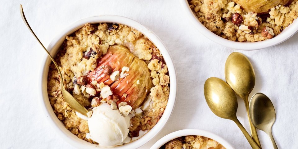 Feestelijke appelcrumble met nootjes en gember Van deze appelcrumble begin je spontaan te glimlachen van blijdschap. We dienen hem op in verschillende potjes met gouden lepeltjes en een bolletje vanilleijs recht van bij de boer.