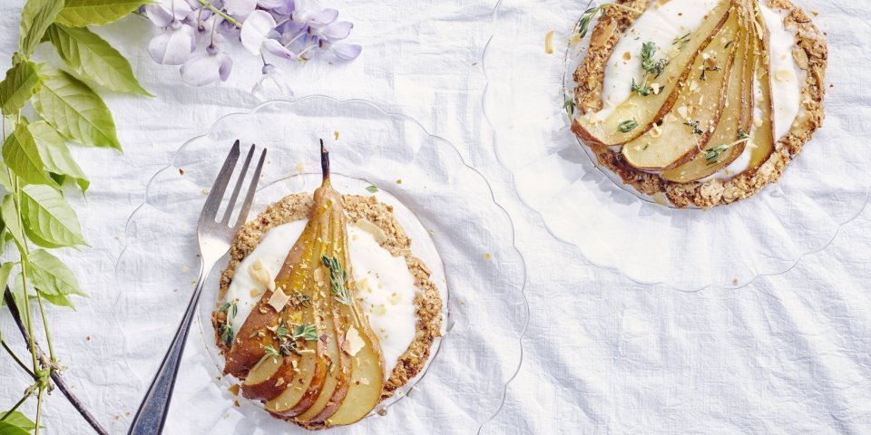 Krokante perentaart Deze taart heeft een krokante bodem van amandel en hazelnoten. Ze is bedekt met yoghurt, honing, tijm en een heerlijke verse peer van bij ons!