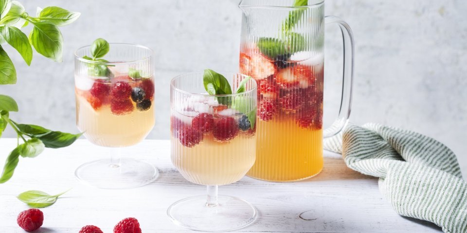 Mocktail met kombucha, frambozen en blauwe bessen Een heerlijke verkoelende mocktail klaargemaakt in een grote karaf. Er werden al twee glaasje uitgeschonken met verse framboosjes en basilicum afgewerkt. Een plaatje om naar te kijken en er meteen van te drinken.