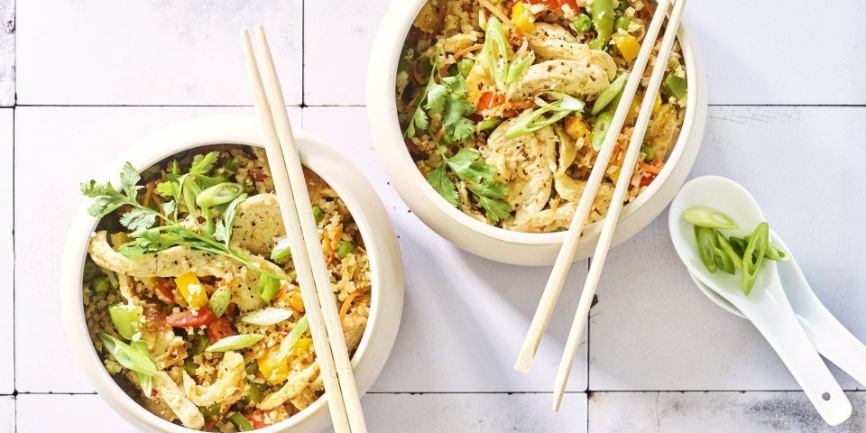 Twee kommetjes staan op het aanrecht. Wij maakten een op-en-top Belgische variant op de Nasi goreng, nl eentje met bloemkoolrijst, paprika, erwtjes en kip van bij ons. 
