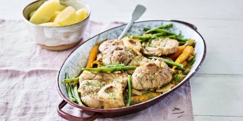 Ossobuco met wortel en boontjes De kalfsschenkels liggen in een ovenschotel met groene boontjes en oranje wortels erbij. Dit zorgt voor een mooie variant op de klassieke ossobuco.