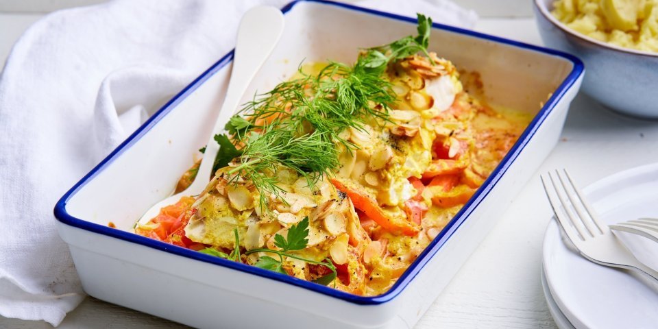 Een gevulde ovenschotel staat op tafel, hij is gemaakt met schijfjes tomaten en hierop de vis. We voegden wat saus toe op basis van mosterd, om het gerecht een extra boost te geven. Wij serveren hem met aardappelpuree.