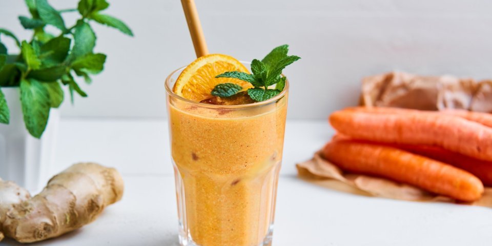 Smoothie van wortel, havermout en sinaasappel Op het aanrecht staat een knaloranje smoothie. Hoe? Door de wortel en sinaasappelsap. Wij maakten hem nog specialer door havermout, cashewnoten, gember en honing toe te voegen.