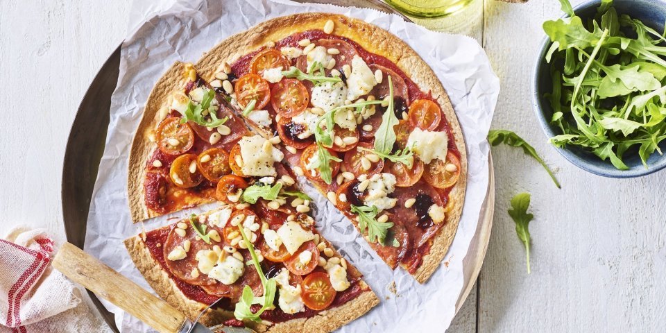 Een snelle pizza op tafelen toveren doe je met deze tortizza. De pizzabodem maakten we van een tortilla waar we lekkers aan toevoegde. Denk maar aan tomaatjes, salami en geitenkaas. We voegden ook nog een handje rucola toe voor de kleur. De pizza ligt al aangesneden op een groot bord. 