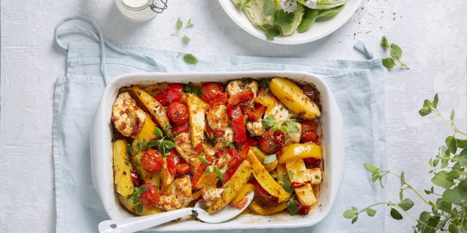 Traybake met aardappelwedges, groenten en kip Een heerlijke hoofdmaaltijd in één ovenschaal met stukjes aardappel, tomaten, paprika en kip. Er is ook een knapperige salade van little gem met yoghurtdressing.