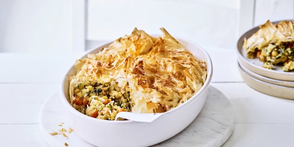 Vegetarische pastilla Pastilla is een hartige pastei met een zoete touch. Pastilla maak je met filodeeg, de traditionele is met kip maar wij maakte een vegetarische versie. Hier is hij opgediend in een grote witte ovenschotel waaruit al 1 portie is uitgeschept en naast de schotel staat.