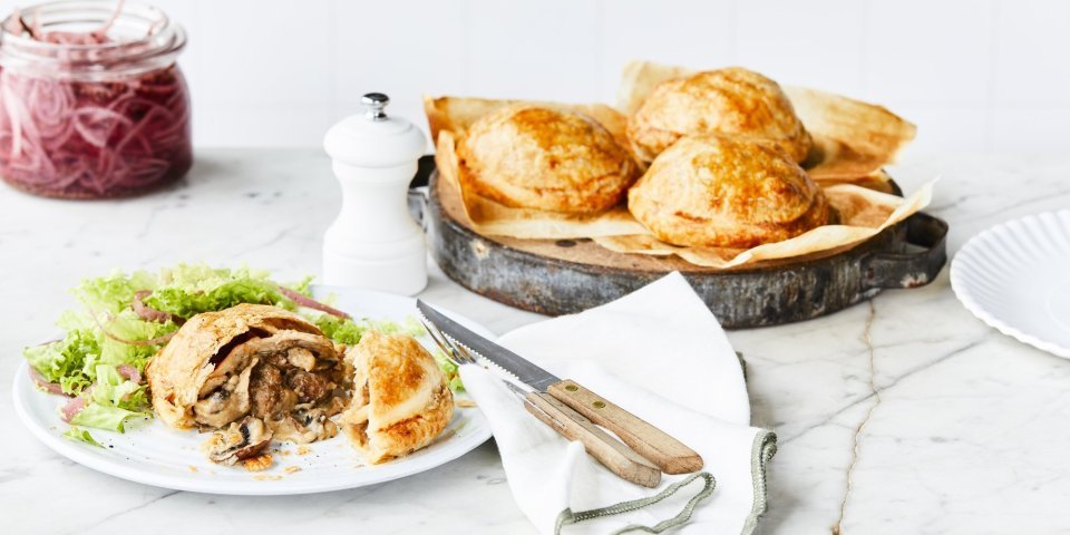 Vol-au-vent taartjes Achterin de foto staat een schaal met hierop 3 vol-au-vent taartjes. Vooraan in het beeld ligt er één taartje aangesneden. Met wat sla erbij en ingemaakte rode ui.