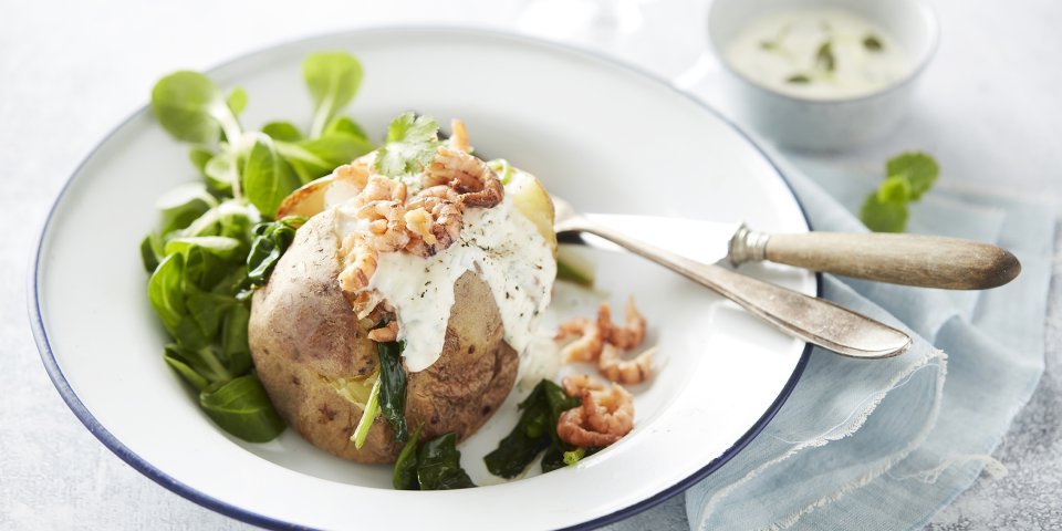 Gepofte aardappel in de schil met zure room, spinazie en garnaaltjes Gepofte aardappel in de schil met zure room, spinazie en garnaaltjes