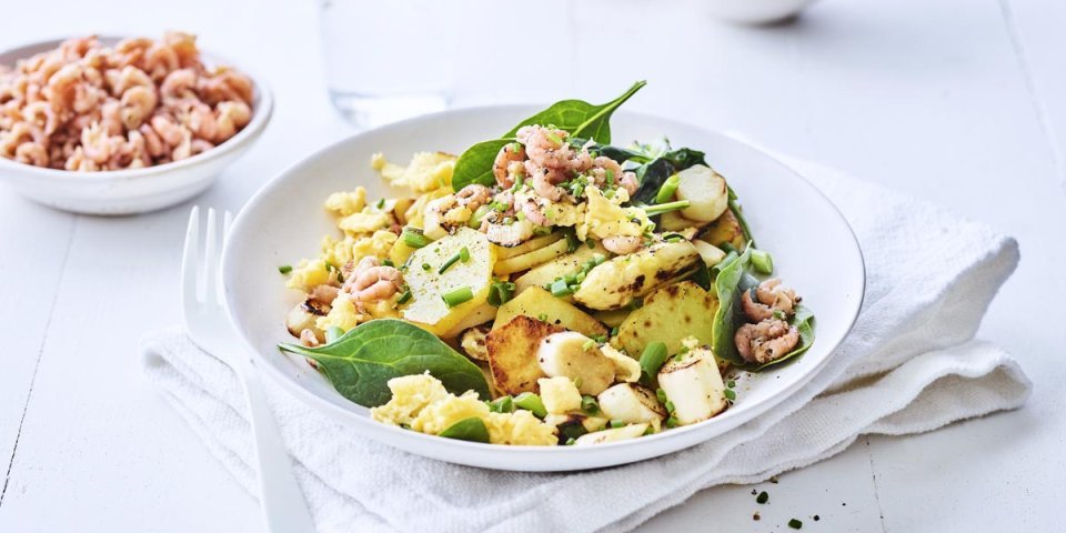 Wok de pommes de terre, asperges, épinards et crevettes