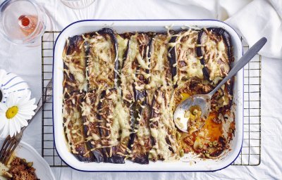 Een grote ovenschotel met aardappellasagne staat op tafel. Er is al een portie uitgedeeld, maar er zijn er nog 5 te verdelen. Perfect te combineren met een glaasje rosé. 