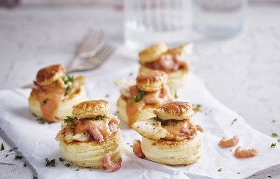 Verschillende bladerdeeghapjes staan op tafel. Ze zijn gevuld met een vol-au-vent op basis van vis, nl steenbolk. 