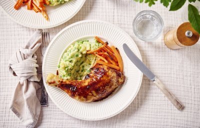 Op tafel ligt een leuk tafelkleed, met ruitjes ingeduwd. Hierop staat het eten geserveerd. In een wit rond bord, eerst de puree, dan de kippenbout en dan nog wat worteltjes. 