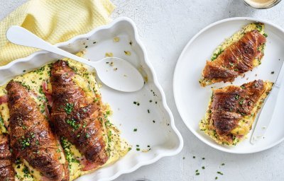 Er staat een witte ovenschotel op tafel gevuld met croissants. Ze zijn doormidden gesneden, bestrijkt met mosterd en belegd met ham en kaas. Daarna is een beslag toegevoegd en werden ze 10 minuten in de oven geplaatst. Om vingers en duimen van af te likken, al zeg ik het zelf.