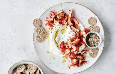 Smeuïge kaasdip met kruidige aardbeien en crackers. Perfect zomers hapje om het aperitief mee te starten.