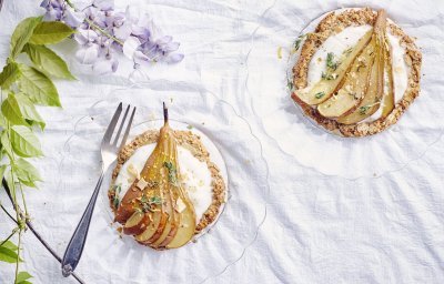 Deze taart heeft een krokante bodem van amandel en hazelnoten. Ze is bedekt met yoghurt, honing, tijm en een heerlijke verse peer van bij ons!