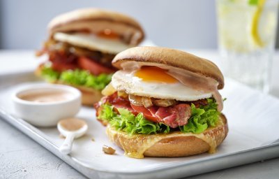 Een burger als ontbijt, dat is er eentje met een spiegelei, spek en groentjes. Er liggen twee stuks op een schaaltje met het sausje erbij geserveerd in een potje, klaar om te proeven. 