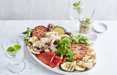 Een grote schaal gevuld met de salade van inktvis en gegrilde groenten zoals tomaten, paprika en courgette. Een topper in het zuiden boordevol zomerse ingrediënten van bij ons. 